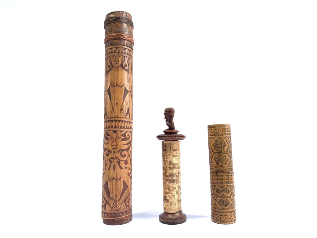 An image of traditional Indonesian heirloom objects including a kris, a betel nut container, a water container, and jewelry with intricate carvings and patterns.