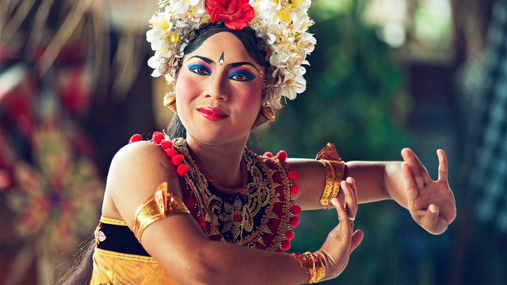 A young woman in traditional Balinese costume performs a Balinese dance, which is a form of Indonesian mythological storytelling.