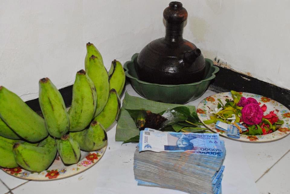 A ritual offering of bananas, flowers, and money without tumbal as part of a pesugihan ritual.