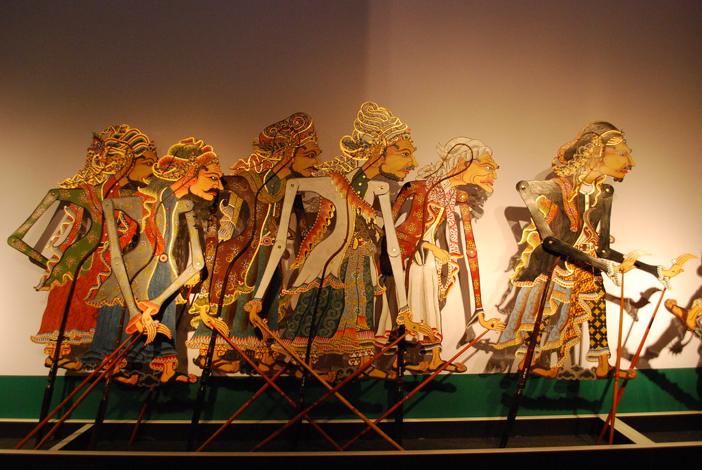 An image of a row of intricately designed Javanese shadow puppets, depicting characters from the Mahabharata and Ramayana stories that represent goodness and wisdom.