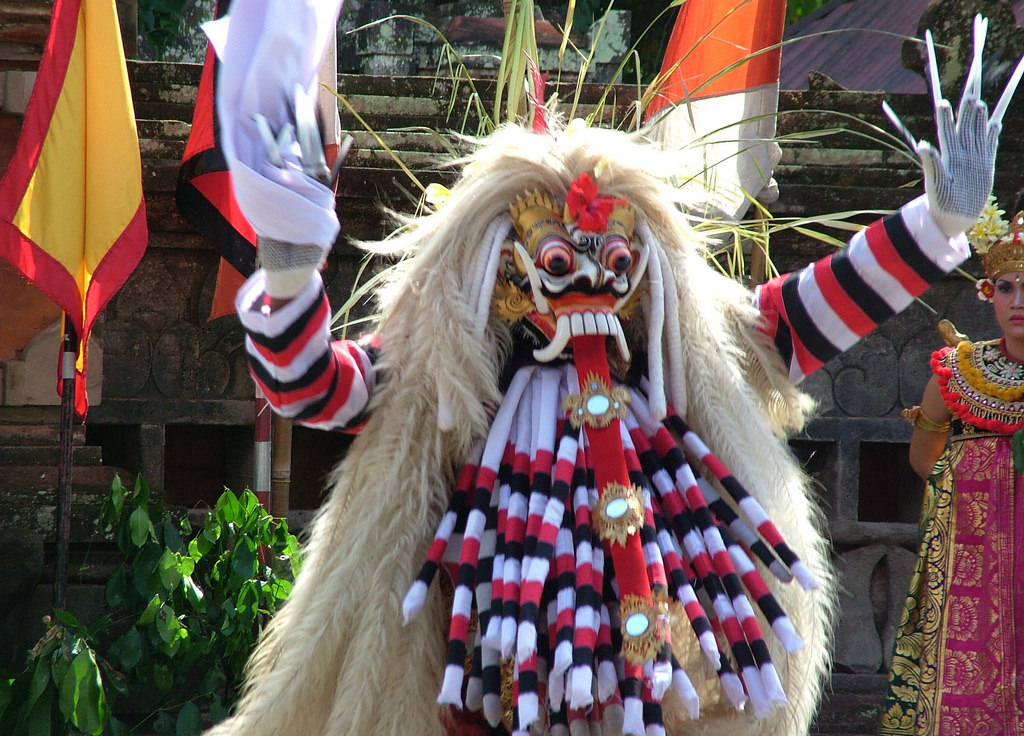 A Balinese man wearing a traditional costume and mask performs a leak dance, a traditional Balinese dance that depicts a mythological creature.
