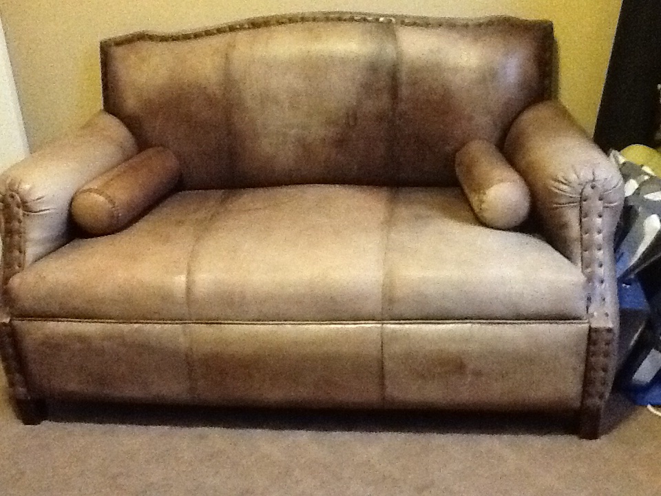A photo of a vintage leather couch with the query 'Indonesian heirloom artifacts'.