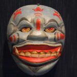 A wooden mask, painted blue with red details, that is used in traditional Indonesian dance performances.