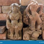 Two stone statues believed to be heirlooms from the Majapahit Kingdom, displayed in front of a brick wall.
