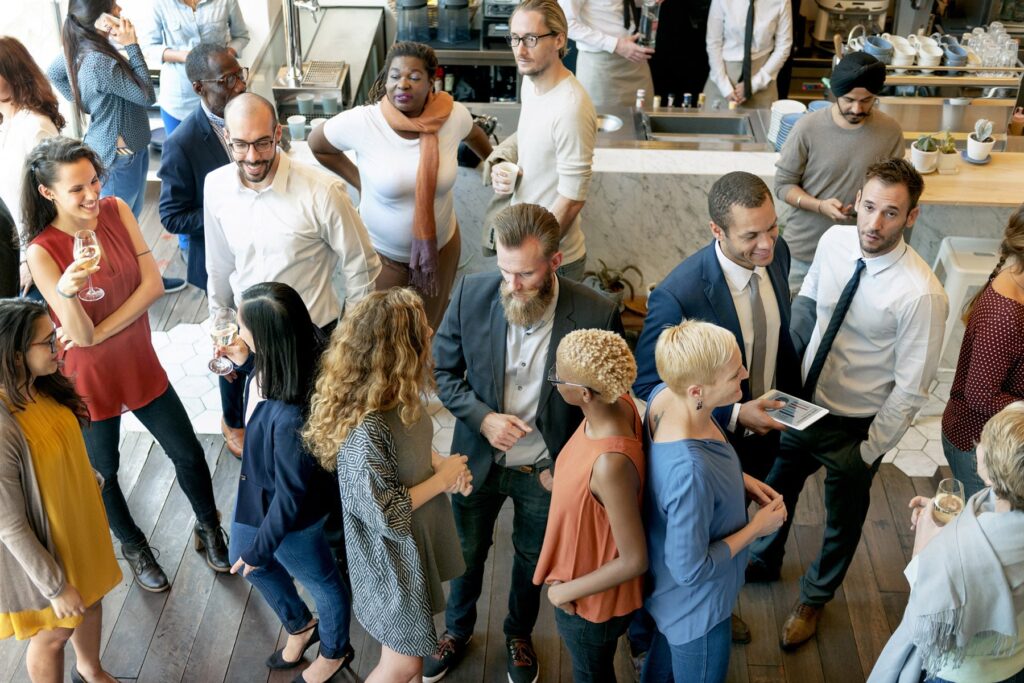A group of diverse people are networking and socializing at a business conference.
